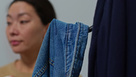 close up of woman returning from shopping hanging up coat on stand before carrying bag into home 2