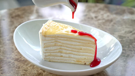 vanilla crepe cake with raspberry and strawberry sauce on plate