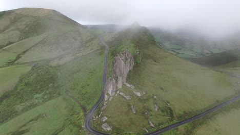 Backwards-shot-clouds-reveal-Rocha-dos-Frades-rock-at-Flores-Azores---Drone-shot