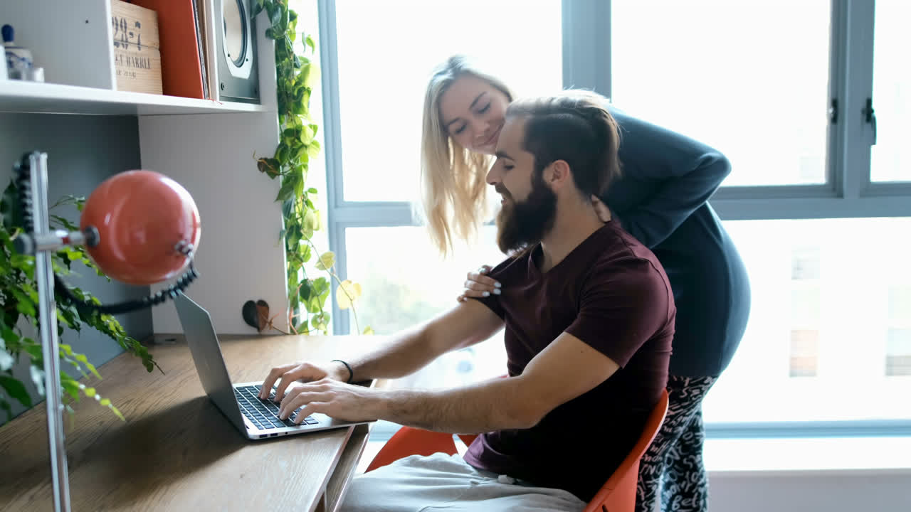 hombre usando computadora portátil mientras la mujer lo abraza desde detrás de 4k