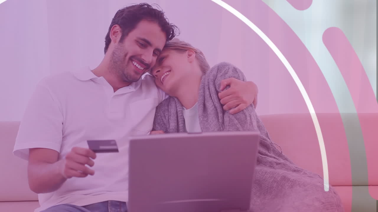 animación de formas sobre una pareja caucásica usando una computadora portátil