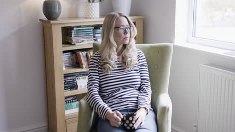 woman relaxing in armchair at home