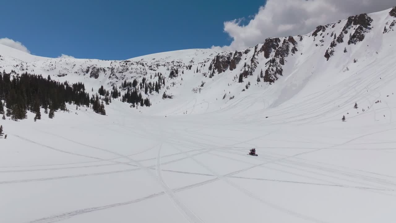 Motoslitta Montezuma Deer Creek inverno primavera neve fresca nell'entroterra immagini aeree con drone Colorado valanga terreno cornice scivolo tracce cime delle Montagne Rocciose cielo azzurro soleggiato nuvole statico