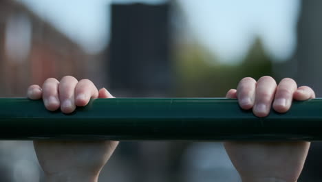 Slow-motion-close-up-as-a-child-hangs-on-to-a-metal-bar-and-then-lets-go