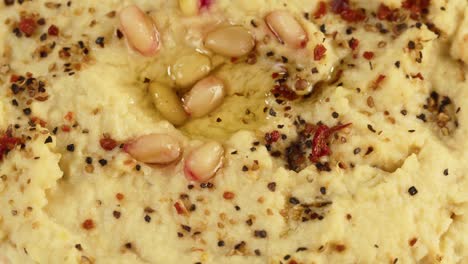 israeli cuisine. hummus texture decorated with spices close-up. national food, middle eastern culture. vegan chickpea puree snack. appetizer made from mashed chickpeas