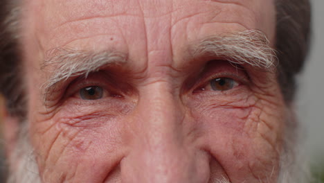 retrato macro de primer plano extremo de la cara arrugada, los ojos de un viejo y hermoso hombre senior mirando a la cámara