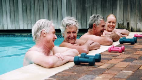 seniors relaxing while interacting near poolside