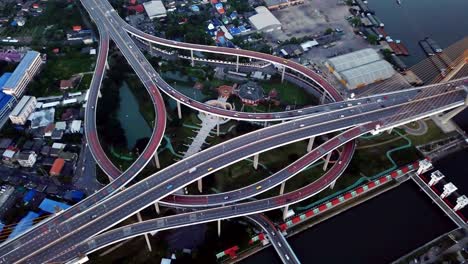 cars driving on roads and circular shaped highways. aerial top view of bhumibol bridge in structure of suspension architecture concept, urban city, bangkok, thailand.