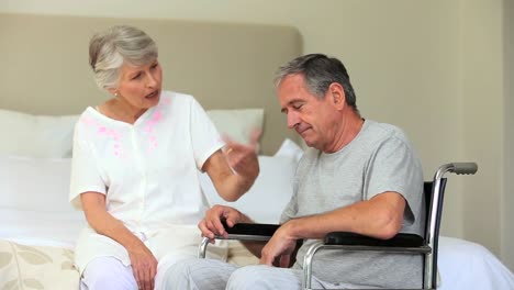 man in wheelchair speaking with his wife