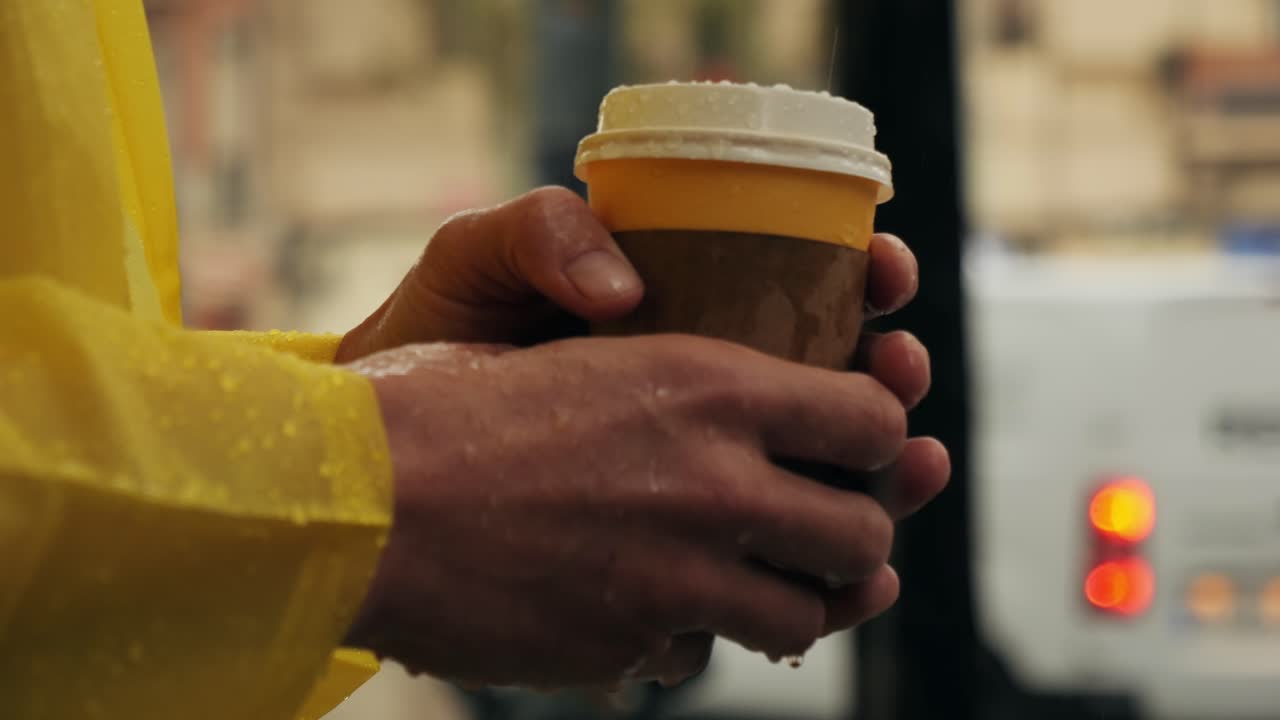 Business man tourist person with umbrella and raincoat on rainy european city street, lights reflecting, walking in Barcelona or Amsterdam during the rain
