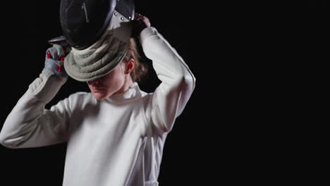 a fencer in a white uniform and mask prepares for a duel