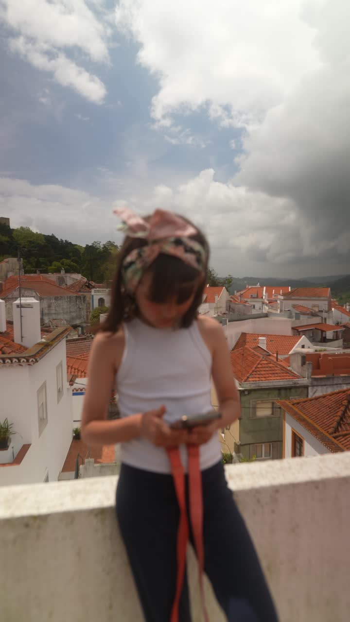 Young girl using a smartphone on a rooftop