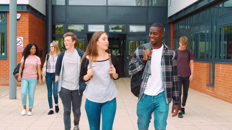 Group Of Students Walking Outside College Buildings