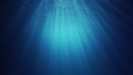 rayos de luz solar bajo el agua que brillan desde arriba atravesando el agua azul cristalina profunda causando una hermosa cortina de reflejos de iluminación de agua