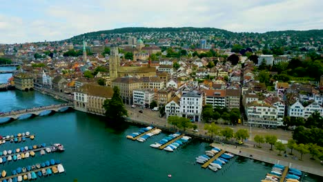 4k drone video of the historic grossmünster, fraumünster, and st. peter churches on the banks of the limmat river in downtown zurich, switzerland