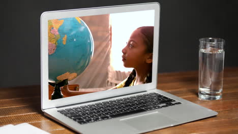 animation of a laptop showing biracial girl looking at a globe on the screen