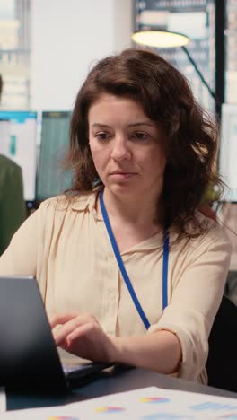 vertical video female general director reviewing data insights on her laptop