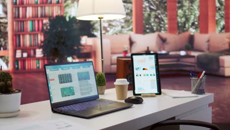 oficina en casa vacía con tableta y portátil muestra infografías y datos contables