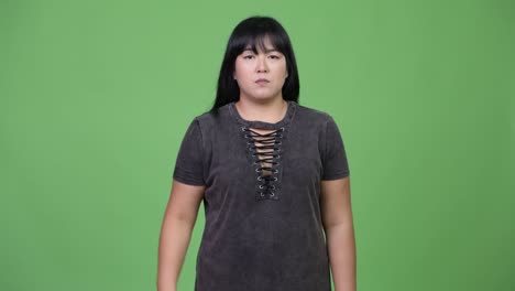 beautiful overweight asian woman pointing finger up