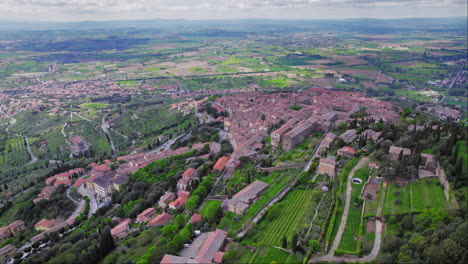 Wide-forward-aerial-of-small-old-town-of-Cortona-in-Tuscany,-Italy