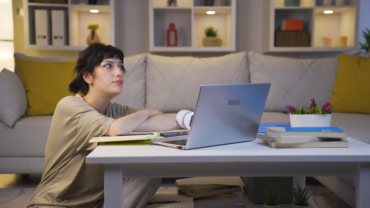 슬프고 불행한 젊은 여성이 밤에 집에서 음악을 듣고 있습니다.