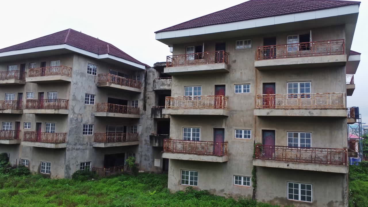 Jib down of an old and abandoned apartment building with poorly maintained balconies in Nigeria, Africa