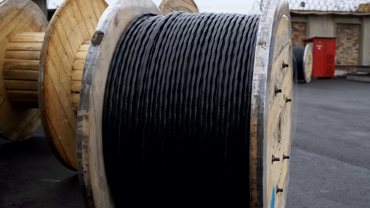 grandes bobinas de cable de madera en la planta de cables en el sitio. la bahía con un cable preparado para la carga en la fábrica de cables.