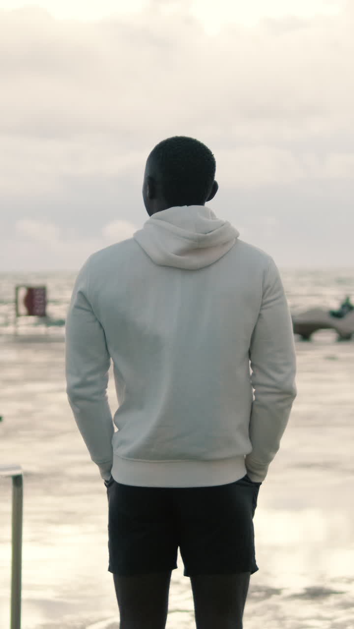 Rear View of Man Looking Out at the Ocean from the Beach