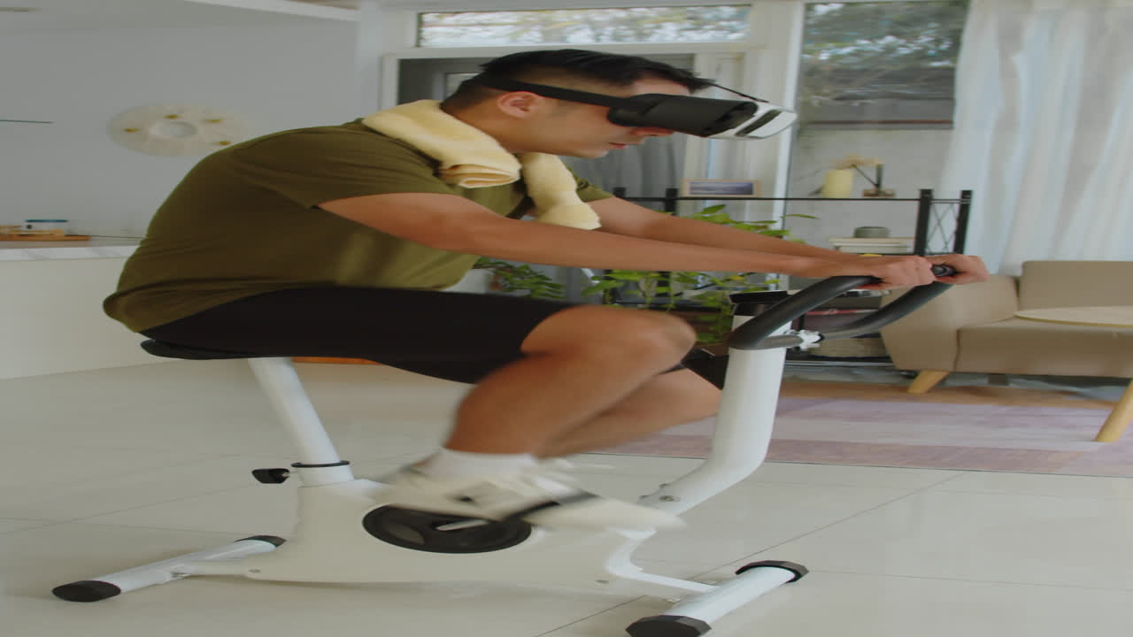 Man in VR Headset Cycling on Fitness Bike Indoors