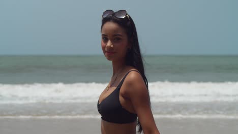 Nahaufnahme-Eines-Hispanischen-Mädchens,-Das-Am-Strand-Spaziert,-Während-Im-Hintergrund-Die-Meereswellen-Tosen