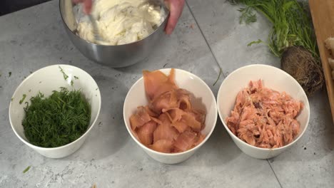 sour cream and cream cheese mixed in bowl, salmon and dill in bowls