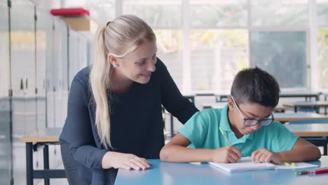 Profesor-De-Escuela-Feliz-Explicando-La-Tarea-A-Su-Alumno