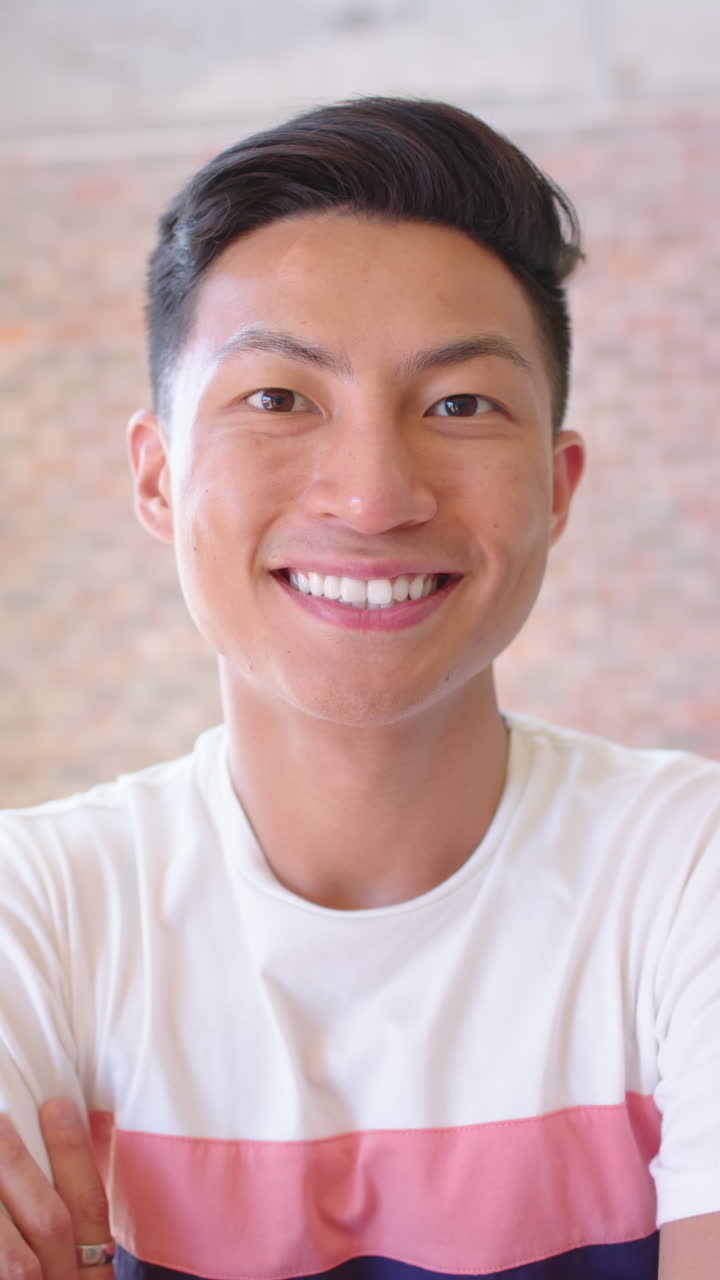 Vertical video portrait of happy asian businessman smiling in office, slow motion