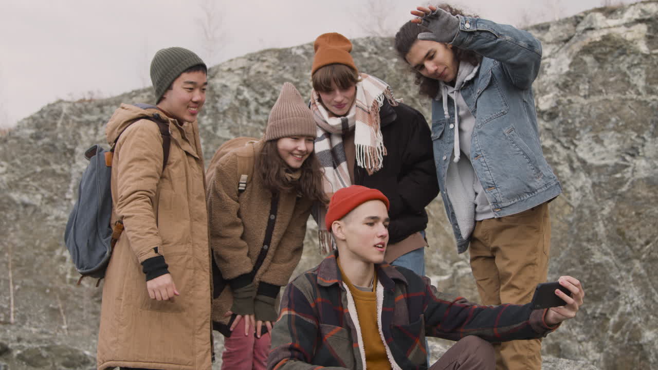 grupo de amigos adolescentes vestidos con ropa de invierno tomando un selfie en la montaña
