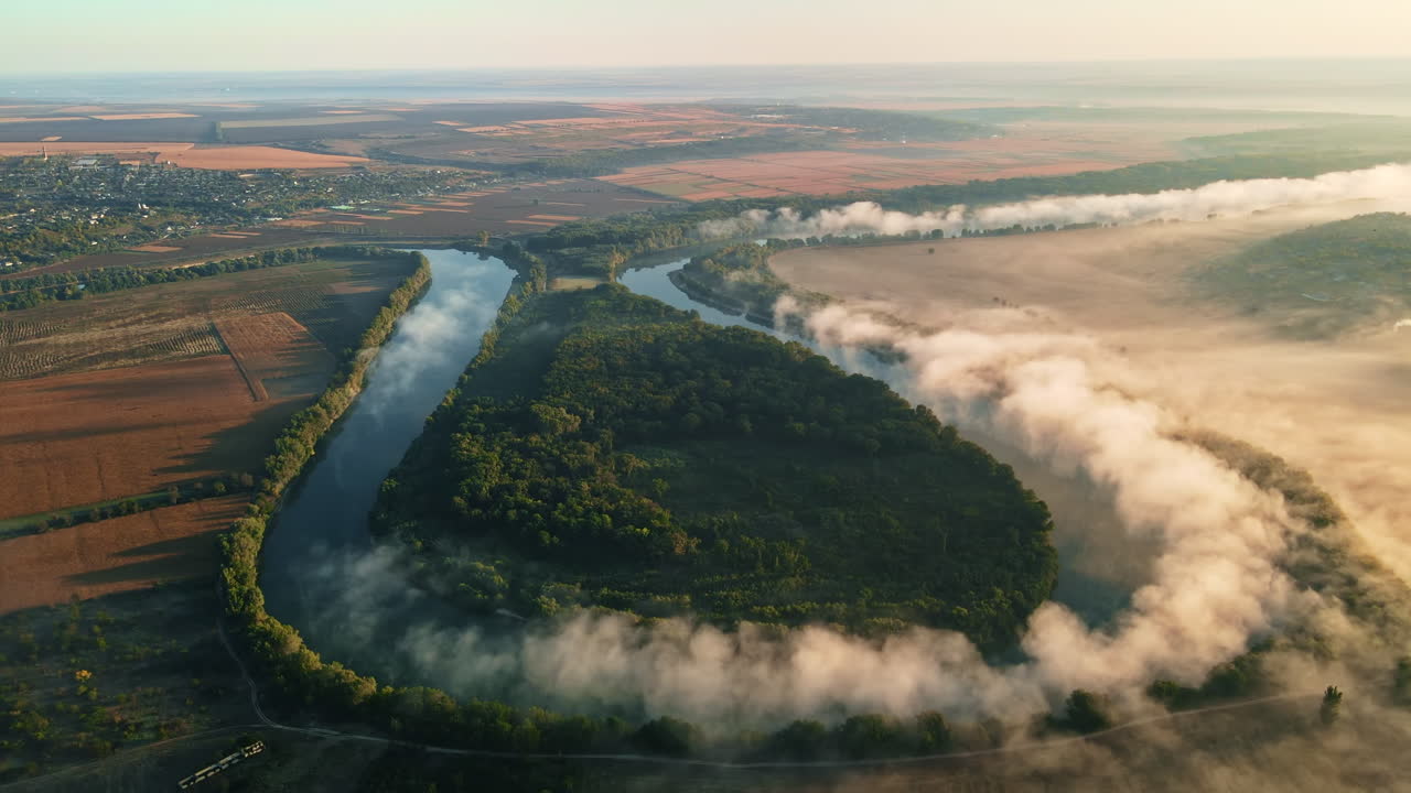 Dronebilde av naturen i Moldova ved solnedgang. Elv og frodig tåke over, landsby, grøntområder