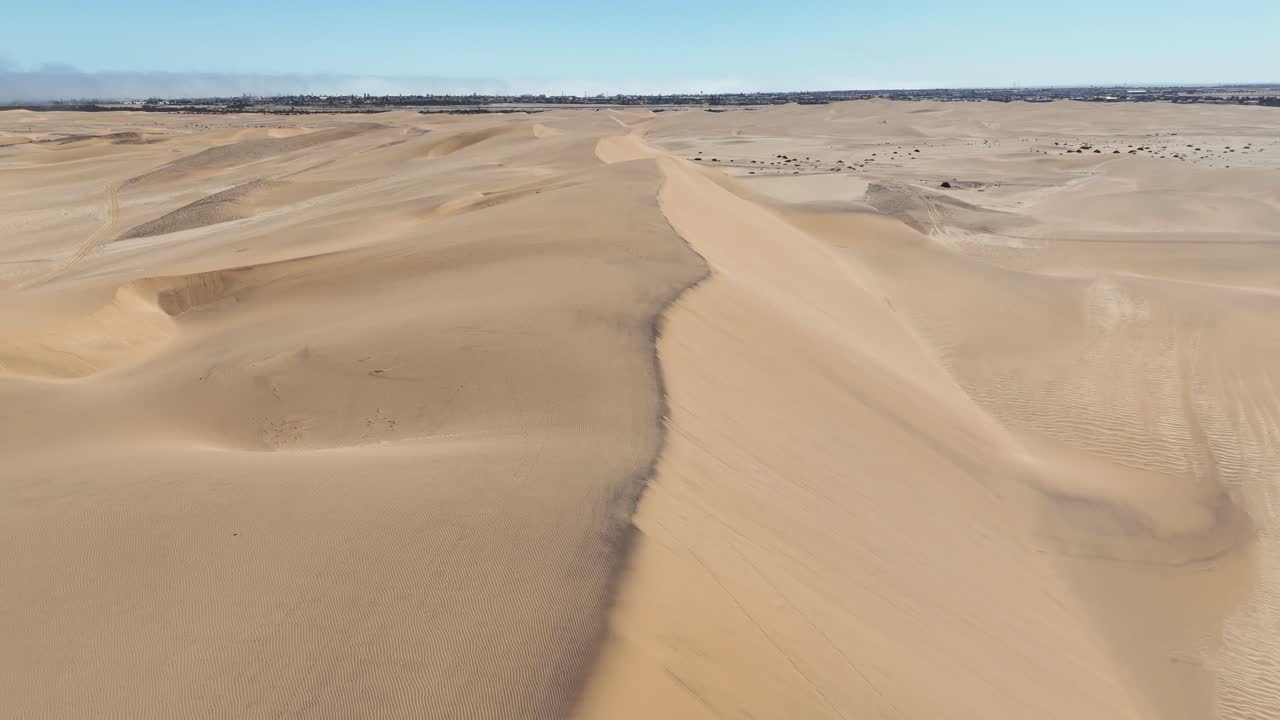 Aerial drone view of the Namib Desert dunes near Swakopmund, Namibia, where golden sand meets the deep blue Atlantic Ocean