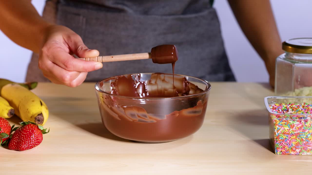 preparando una salsa de chocolate con frutas y salpicaduras