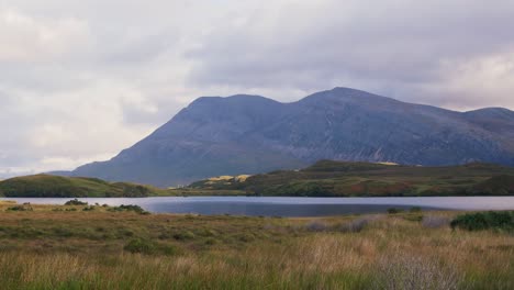loch stack in the scottish highlands near lairg, with calm water, rugged mountain range, and wild moorland scenery under soft highland light