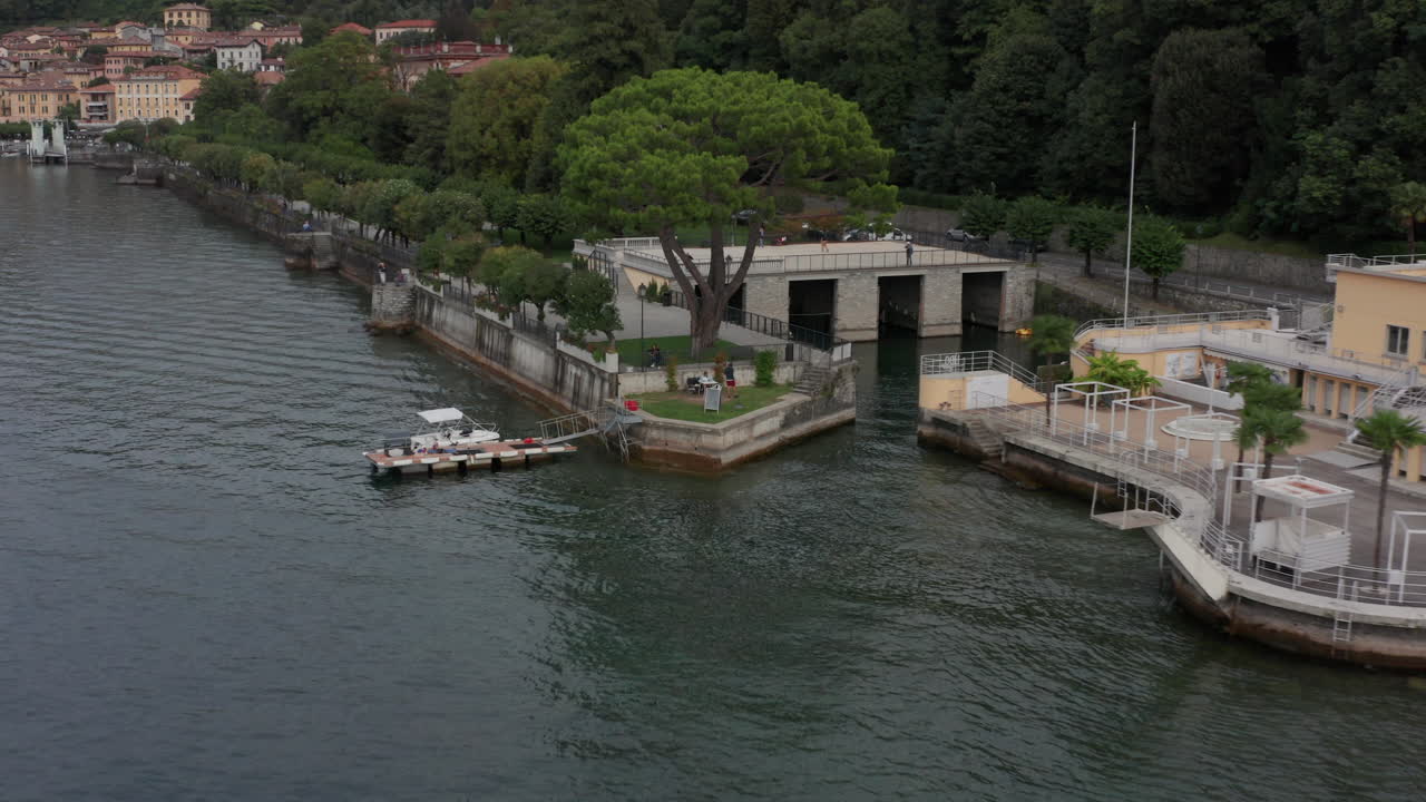 Drone pulling back from people at pier at Lake Como, Italy