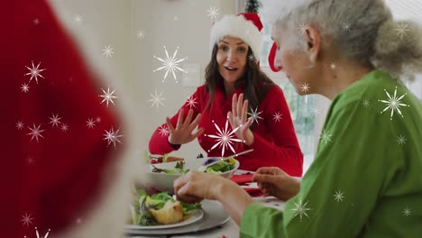 Animation-of-snowflakes-over-caucasian-family-wearing-santa-hats