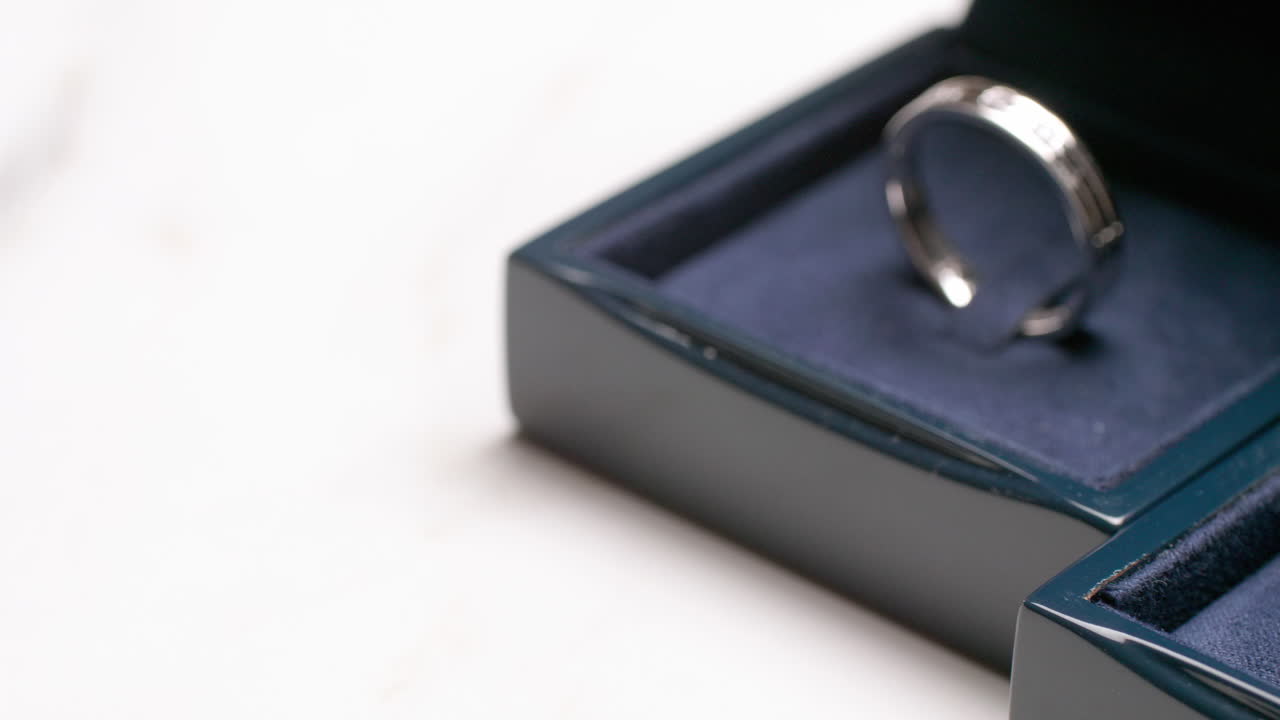 A close-up of a couple's engagement rings that is placed on a dark-blue, velvet-covered box