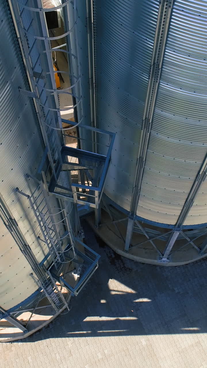Grain Cooperative. Large aluminum containers for storing loose grain. Aerial view Vertical video