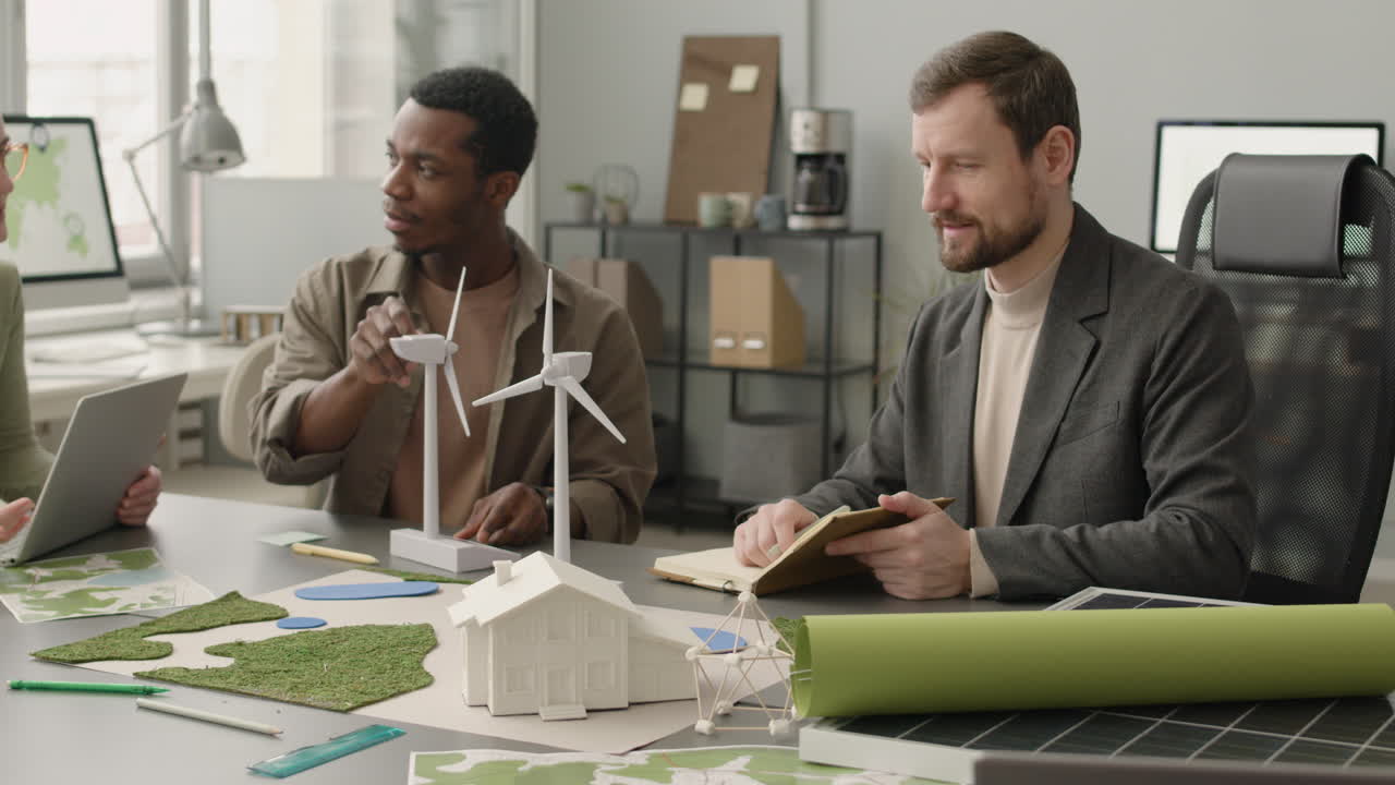 사무실에서 재생 에너지 프로젝트에 대해 논의하는 다민족 비즈니스 팀