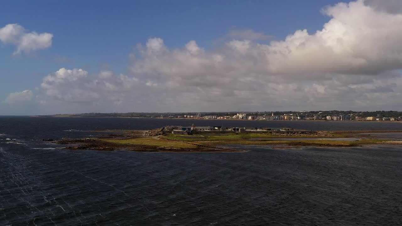 drone estableciendo una visión general del terreno rocoso de la isla de mutton y las aguas costeras en la bahía de galway, irlanda, bajo un cielo azul con nubes dispersas