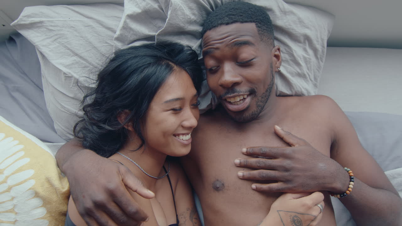 Above View of Cheerful Couple Embracing and Chatting in Bed