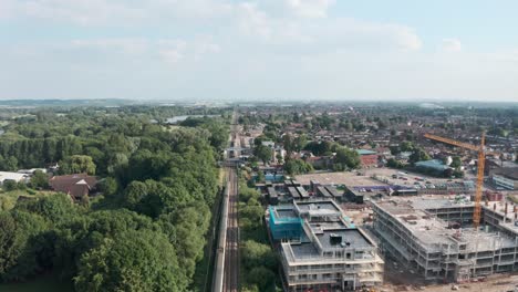 low follow drone shot over british rail train entering cheshunt station north london