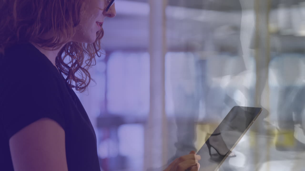 Animation of caucasian businesswoman using tablet over data processing and cityscape