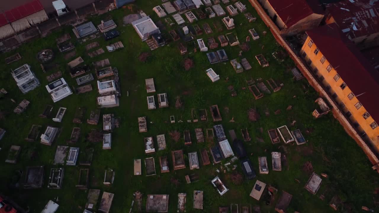Closeup of quiet cemetery under a dim daylight in countryside. Drone fly over the graveyard with tombstones in city of Ibadan, Nigeria, Africa. Aerial footage capture serene and memorial rows of grave