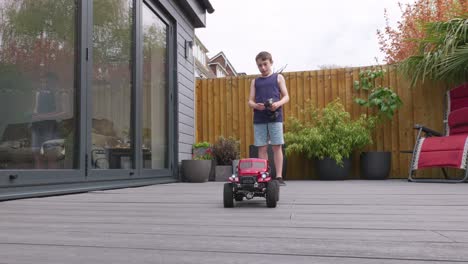 Kleiner-Junge-Zu-Hause-Draußen-Im-Garten-Und-Spielt-Mit-Seinem-Ferngesteuerten-Auto,-LKW,-4-X-4