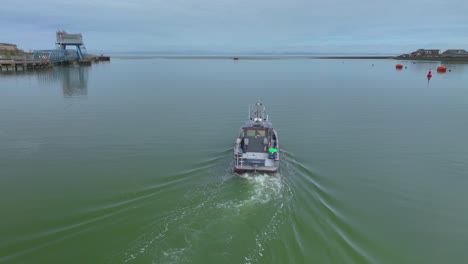 barco de reconocimiento girando lentamente hacia aguas abiertas en un río muy tranquilo
